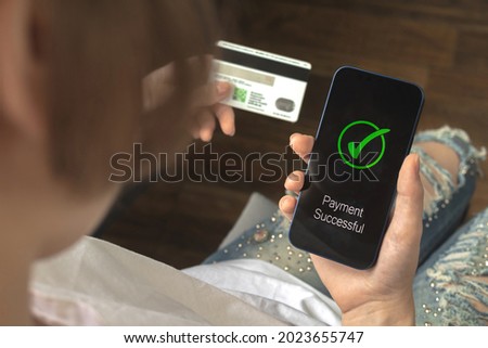 Financial transaction. Woman using mobile phone and hold credit card. Payment successful screen, shopping and e-commerce concept photo