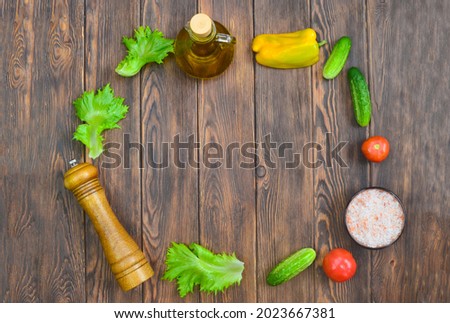 food and culinary background with copy space for text top view, pepper mill, pink himalayan salt and cooking ingredients, fresh vegetables tomatoes, cucumbers  on the kitchen wooden table