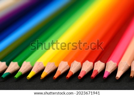 Crayons. Colored pencils on black cardboard background. Education concept. Close-up