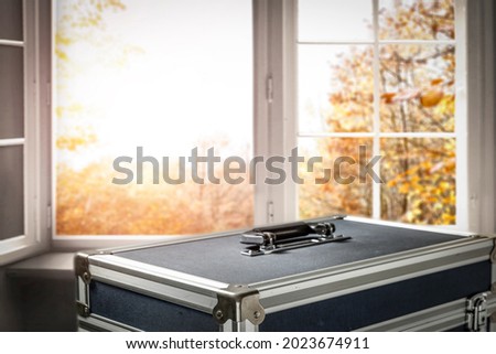 Suitcase for photographic equipment in the landscape of autumn surroundings, before the trip 