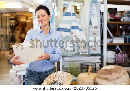 Woman standing with wooden box in decoration and furniture store Royalty-Free Stock Photo #2023705526