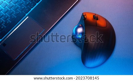 Wireless Trackball Computer mouse near the laptop on a blue background Royalty-Free Stock Photo #2023708145