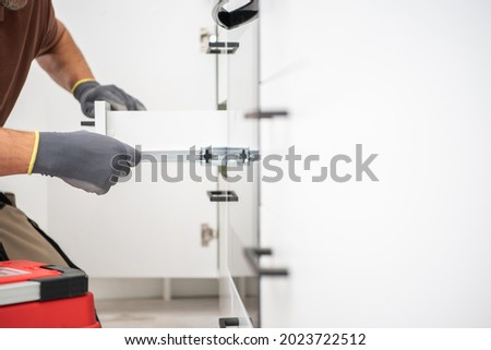 Kitchen Cabinets Drawer Move Testing by Professional Cabinetmaker Close Up Photo. White Clean and Modern Cabinetry. Furnishing Industry. Royalty-Free Stock Photo #2023722512