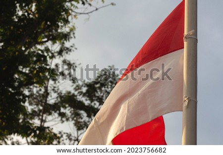 the red and white flag flying in the afternoon. natural sunlight. selective focus concept Indonesian flag.