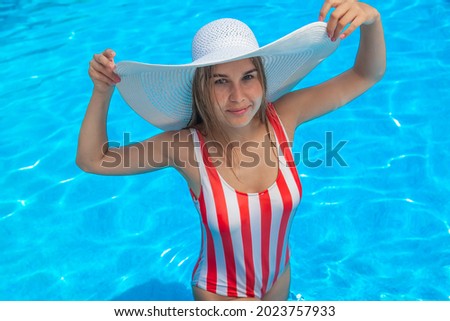 young woman in a swimsuit in the pool in the summer