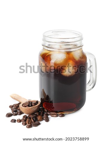Mason jar of tasty cold brew and coffee beans on white background