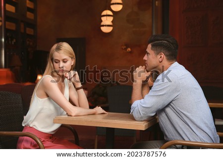 Bored couple having unsuccessful date in cafe Royalty-Free Stock Photo #2023787576