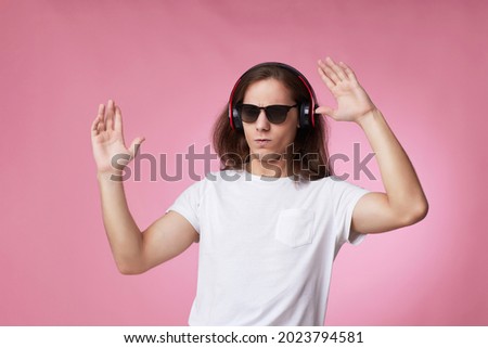 man in sunglasses listens to music with headphones and dances