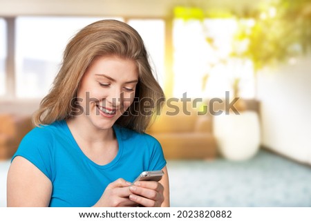 Young happy woman feel excited celebrating bid win looking at a smartphone,