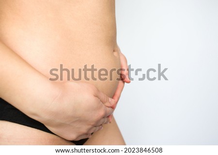 girl holding her belly with her hands on a white background. pregnancy, bloating, excess weight, bowel problems, abdominal and back pain.
 Royalty-Free Stock Photo #2023846508