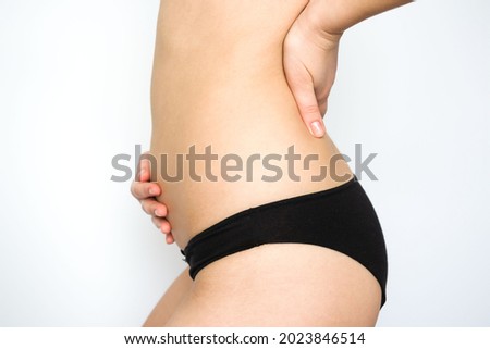 girl holding her belly with her hands on a white background. pregnancy, bloating, excess weight, bowel problems, abdominal and back pain.
 Royalty-Free Stock Photo #2023846514
