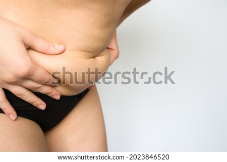 girl holding her belly with her hands on a white background. pregnancy, bloating, excess weight, bowel problems, abdominal and back pain.
 Royalty-Free Stock Photo #2023846520