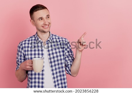 Closeup photo of handsome young man happy positive smile coffee drink point finger empty space isolated pastel background