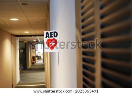   AED Tent Sign on Wall in Office Corridor                             