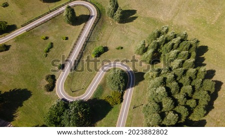 A winding bike path in the park. Winds among trees and bushes. Aerial photography.
