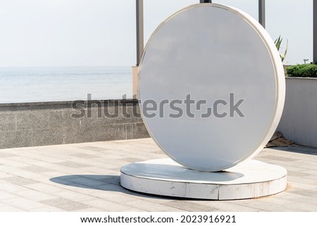 Blank white sign for logo located by the sea on the embankment. Mockup design