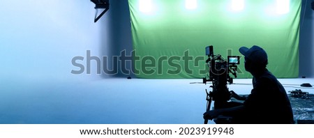 Video production behind the scenes. Making of TV commercial movie that film crew team lightman and cameraman working together with film director in studio. film production concept. Silhouette style. Royalty-Free Stock Photo #2023919948