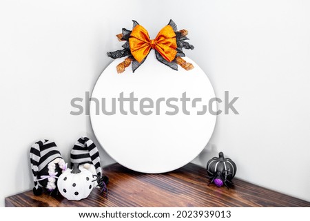 Blank white round wood sign with halloween bow and spooky decor, rustic door sign mockup