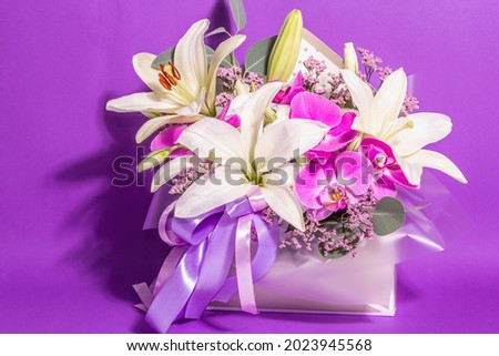 A beautiful bouquet of fresh flowers on a violet background. The festive concept for Weddings, Birthdays, Mother's Day, For Valentine, or March 8th. Greeting card, a place for text, flat lay