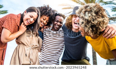 Young happy people laughing together - Multiracial friends group having fun on city street - Diverse culture students portrait celebrating outside - Friendship, community, youth, university concept
