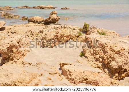 Surface of clear water on tropical sandy beach with stones in Crete Greece