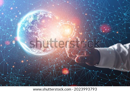 AI concept. Businessman points the goals of global business investment network through advanced AI technology. Earth image from space furnished by NASA.
