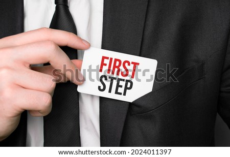 Businessman holding a card with text first step