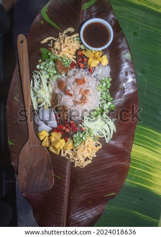 
Fried rice with shrimp paste served on banana leaves by the pool.
red speckled banana leaves in the background.
beautiful color of nature background. food and restaurant concept.
