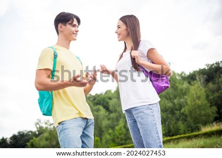 Photo of cute sweet teen boy girl dressed casual outfit rucksack smiling talking walking college outside park Royalty-Free Stock Photo #2024027453