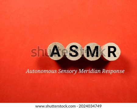 Business concept.Text ASMR writing on block cylinder on a red background.