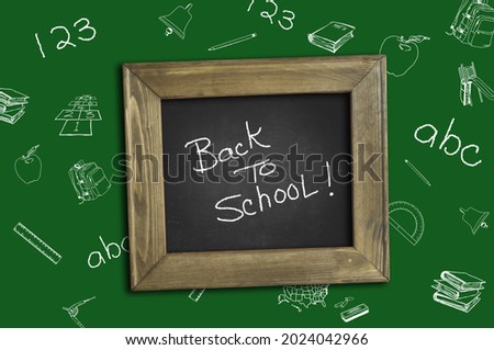 Back to school. School supplies at the table. Green background. Blackboard. Chalkboard