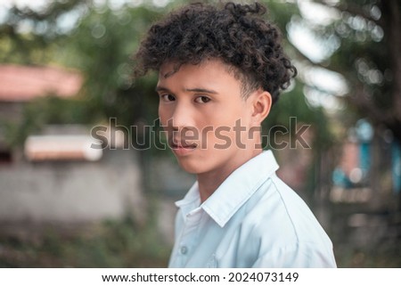 An emotionally hurt and upset young man with sad but angry eyes. Feeling of animosity or holding a grudge. Outdoor scene. Royalty-Free Stock Photo #2024073149