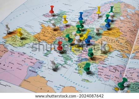 European capitals marked with colored pins on an atlas