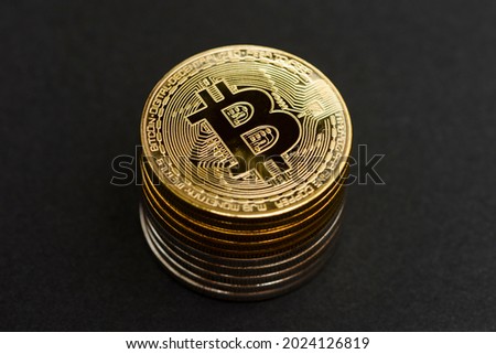 Golden and silver bitcoin stack isolated on the black background.