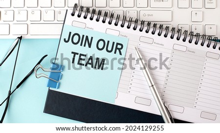 JOIN OUR TEAM text on blue sticker on the planning and keyboard,blue background
