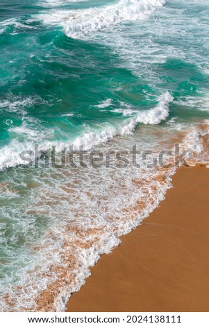 Aerial view of the ocean waves and beach. Blue water background. Sea top view. Atlantic Ocean beach with sand texture