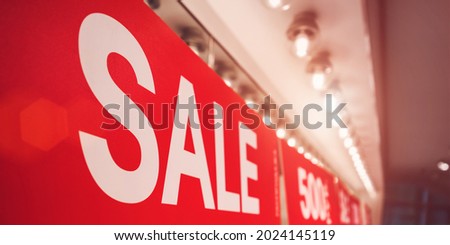 Sale inscription on red long banner hangs on wall during promotion action side close view