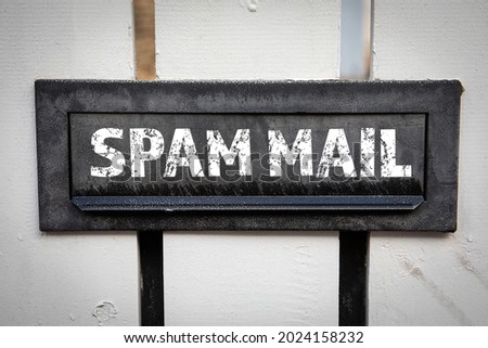 Spam Mail concept. Metal mailbox in a white wooden fence.