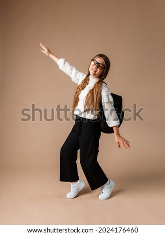 Full length photo of female student walking hugging book with backpack smiling on background