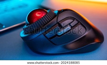 Wireless Trackball Computer mouse near the laptop on a blue background Royalty-Free Stock Photo #2024188085