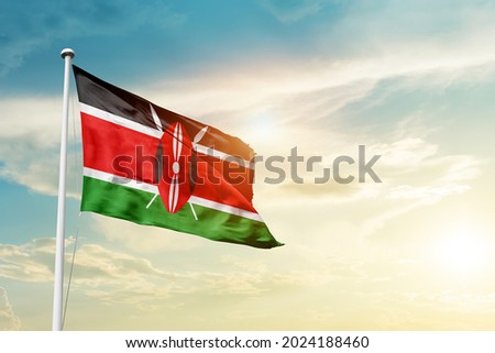 Kenya national flag waving in beautiful clouds.
