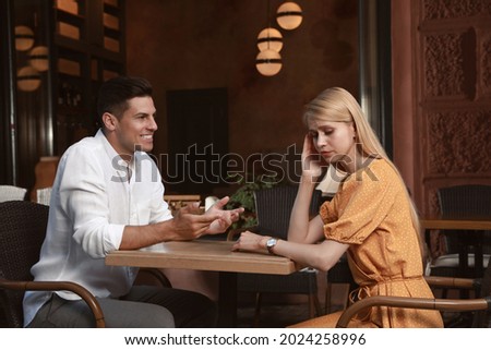 Young woman having boring date with talkative man in outdoor cafe Royalty-Free Stock Photo #2024258996