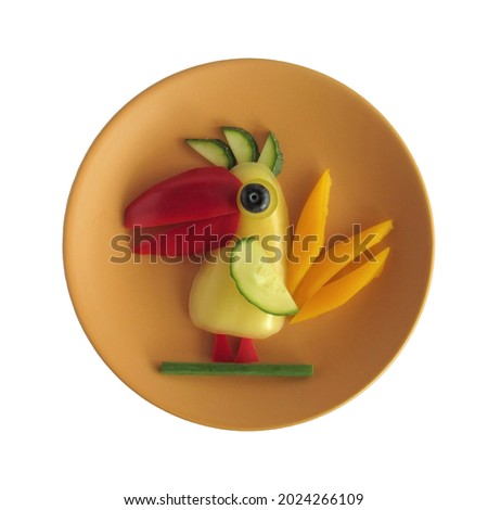 Funny parrot made of vegetables on a ceramic plate. A plate on a white background.