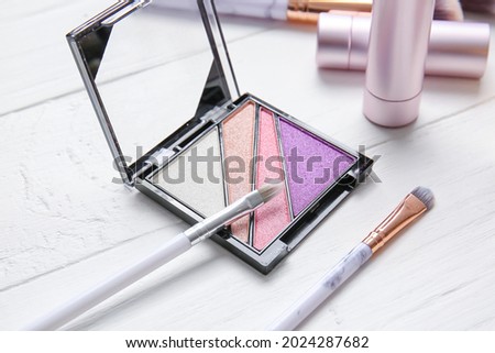 Beautiful eyeshadows and brushes on wooden table
