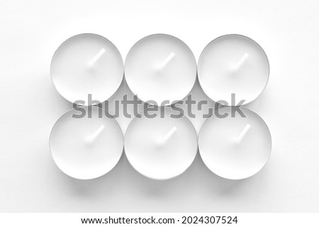White tea light candles on white background.  Royalty-Free Stock Photo #2024307524