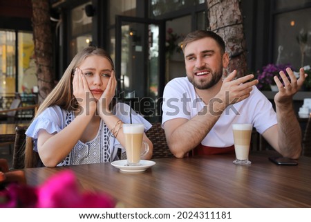 Young woman having boring date with talkative guy in outdoor cafe Royalty-Free Stock Photo #2024311181