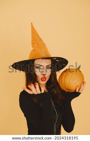 Young woman in haloween costume pose on color background