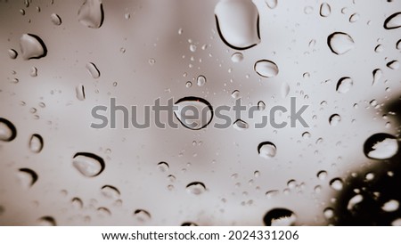 Raindrops outside the car window on a cloudy day