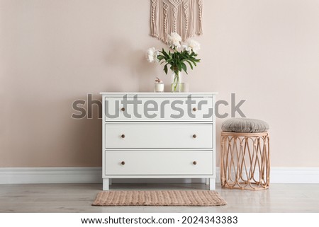 Room interior with white chest of drawers near beige wall Royalty-Free Stock Photo #2024343383