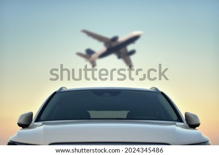 Parked Car in airport with taking off airplane on sky background. Transfer concept. Royalty-Free Stock Photo #2024345486